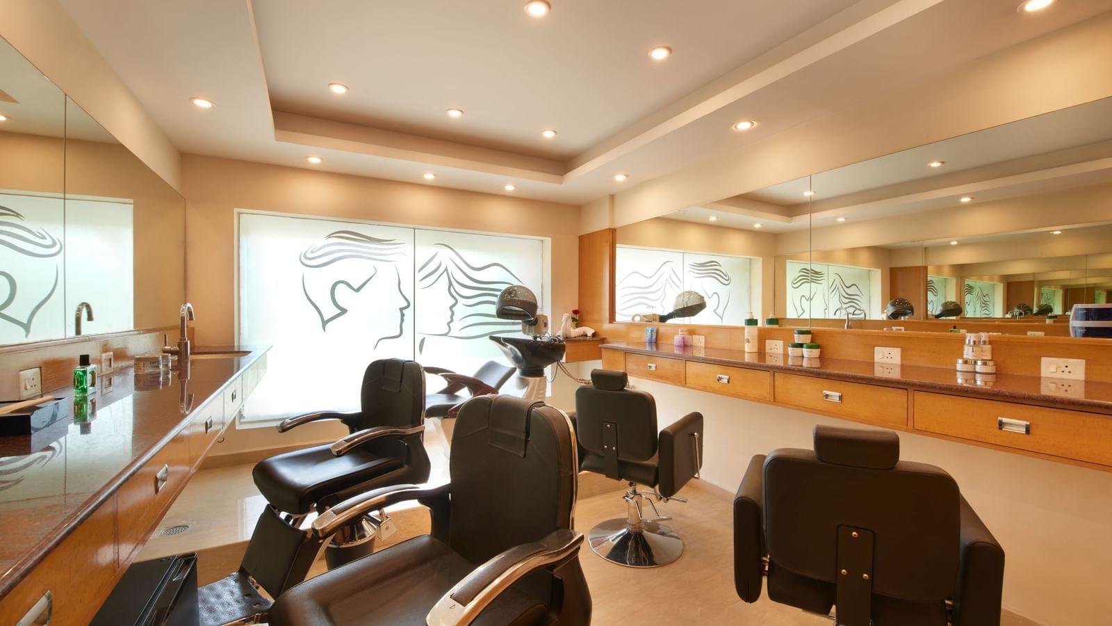 An image of a salon with several chairs, a large mirror fixed on the wall, and beauty products placed on the desk at Accord Puducherry, one of the top 5-star hotels in Puducherry.